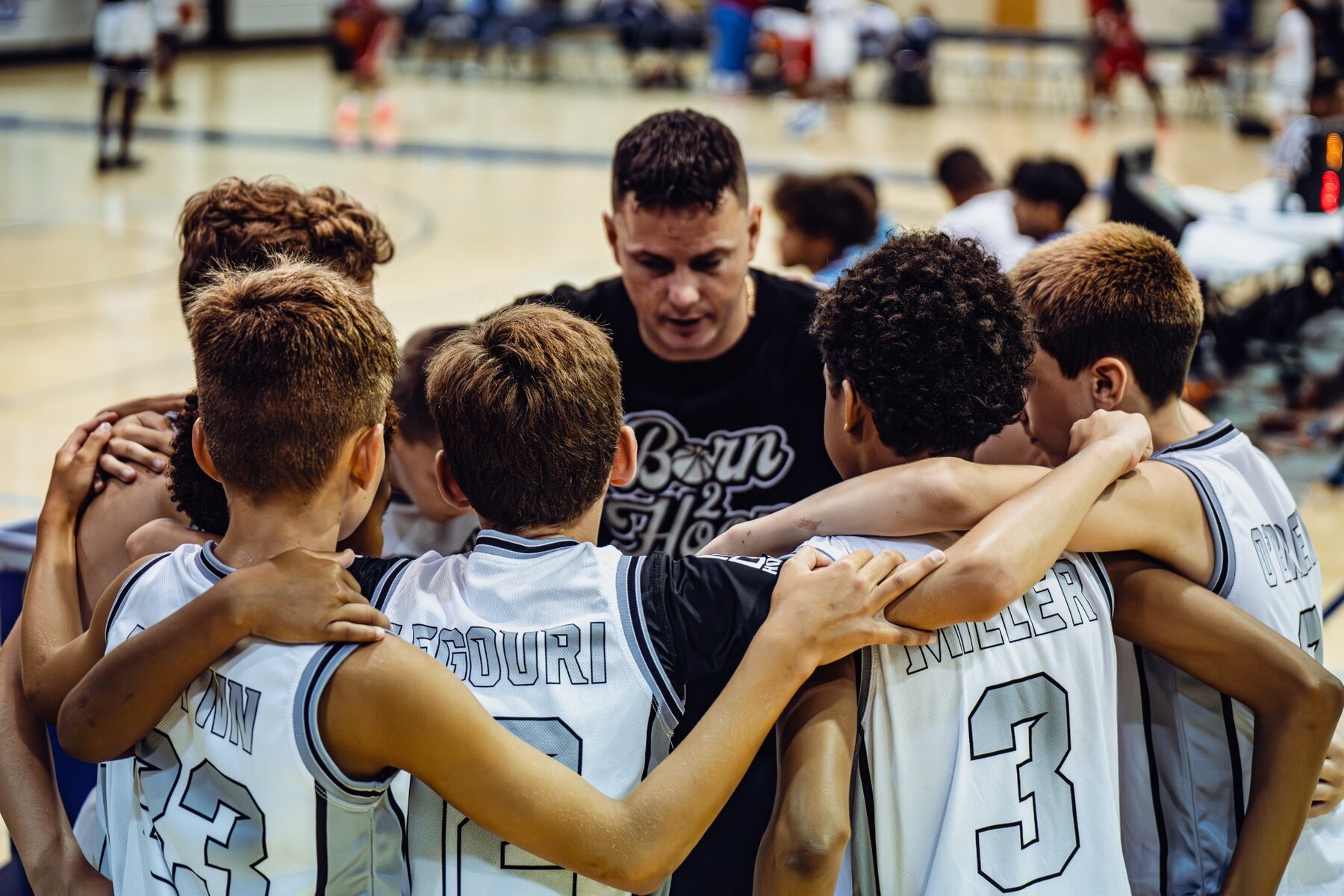 Coach Kevin Miller connecting with Born 2 Hoop players in the team huddle